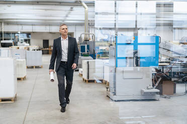 Businessman walking in a factory - DIGF09263