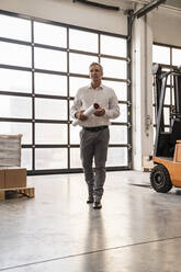 Businessman walking in a factory - DIGF09274