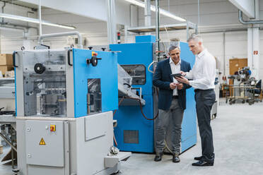 Two businessmen with tablet talking in a factory - DIGF09276