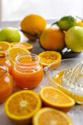 Frisch aufgeschnittene Orangen und Gläser mit Orangensaft - GIOF07923