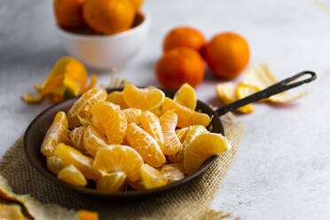 Heap of freshly peeled mandarines on frying pan - GIOF07937