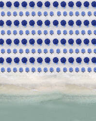 Luftaufnahme von Reihen blauer Sonnenschirme, die am Sandstrand stehen - KNTF04077