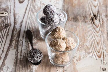 Glasses of vegan protein balls with millet, coconut, cocoa and nuts - EVGF03595