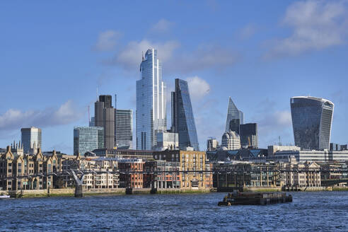 Vereinigtes Königreich, England, London, Kahn fährt unter der Millennium Bridge mit der Skyline der Stadt im Hintergrund - MRF02339