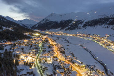 Italien, Provinz Sondrio, Livigno, Luftaufnahme einer beleuchteten Stadt in den italienischen Alpen in der Abenddämmerung - WPEF02421