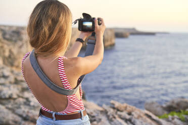 Junge Frau fotografiert das Meer - EPF00678