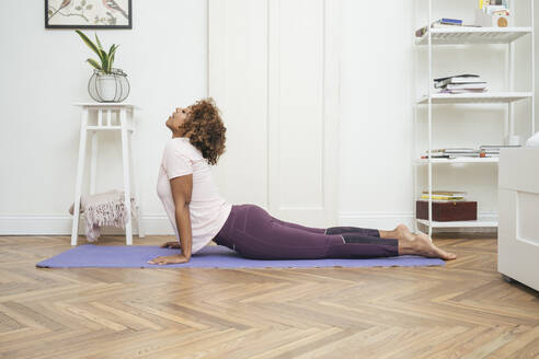 Junge Frau übt Yoga zu Hause - VPIF01944