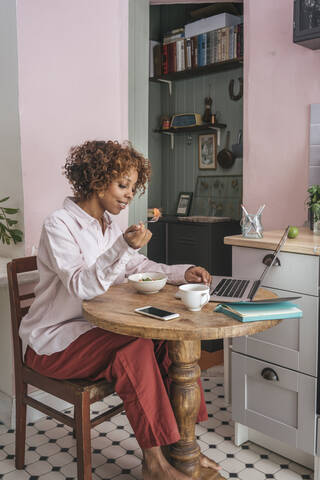 Casual young businesswoman having lunch break at home stock photo