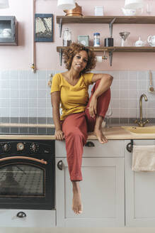 Portrait of relaxed young woman in kitchen - VPIF01986