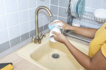 Nahaufnahme einer Frau beim Waschen einer Tasse in der Küche - VPIF01988