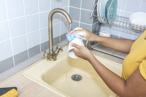 Nahaufnahme einer Frau beim Waschen einer Tasse in der Küche - VPIF01988