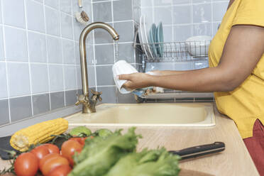 Nahaufnahme einer Frau beim Waschen einer Tasse in der Küche - VPIF01989