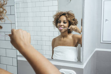 Young woman in bathroom brushing her teeth - VPIF01998