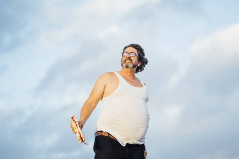 Mann mit Bierbauch hält Sandwich, lizenzfreies Stockfoto