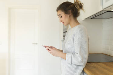 Young woman using smartphone at home - JPTF00398