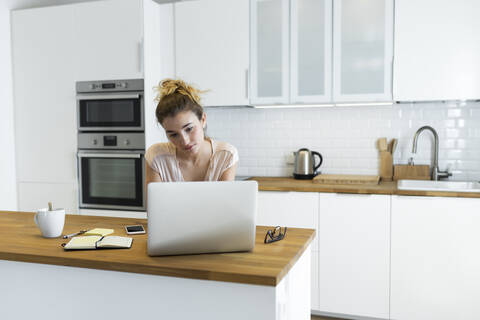 Female teenager using laptop at home stock photo