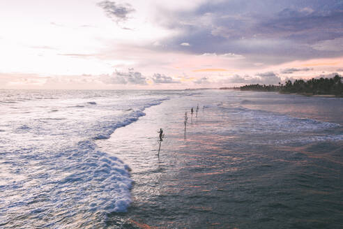 Sri Lanka, Südprovinz, Ahangama, Luftaufnahme von Wellen, die in der Abenddämmerung an den Küstenstrand schlagen - DAWF01115