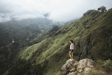 Sri Lanka, Provinz Uva, Ella, Wanderin steht auf Felsblock am Little Adams Peak - DAWF01132