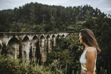 Sri Lanka, Provinz Uva, Demodara, Erwachsene Frau bewundert Blick auf die Nine Arch Bridge - DAWF01135