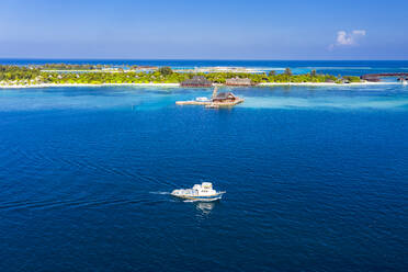 Malediven, Luftaufnahme eines Motorboots, das vor dem Olhuveli Island Tourist Resort fährt - AMF07721