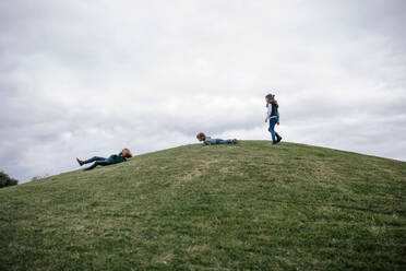 Drei Kinder spielen auf einem Hügel - GRCF00040