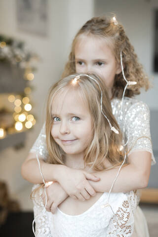 Porträt eines kleinen blonden Mädchens mit Lichterketten geschmückt, lizenzfreies Stockfoto