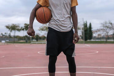 Teenager hält Basketball mit seinem Arm - GRCF00066