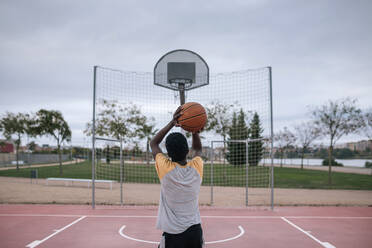 Rear view of teenager playing basketball - GRCF00075