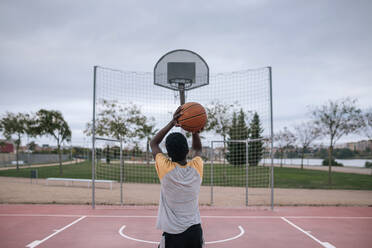 Rückansicht eines Basketball spielenden Teenagers - GRCF00075