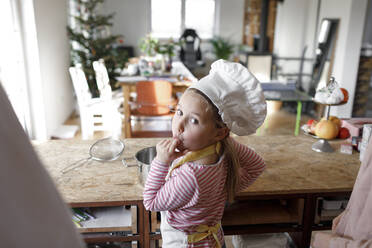 Girl wearing chef's hat in the kitchen - KMKF01165