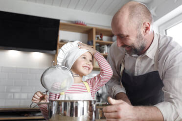 Father and daughter cooking in the kitchen - KMKF01168