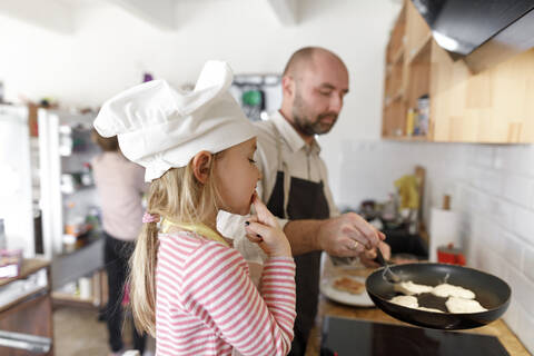 Vater und Tochter beim Kochen in der Küche, lizenzfreies Stockfoto
