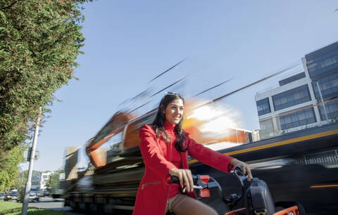 Junge Frau auf Leihfahrrad im Stadtverkehr, lizenzfreies Stockfoto