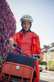 Junge Frau fährt Fahrrad und trägt einen Sicherheitshelm - AJOF00112