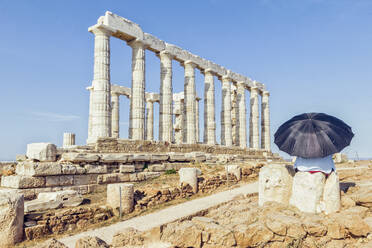 Tourost mit Blick auf die antike Ruine des Poseidon-Tempels, Kap Sounion, Attika, Griechenland - MAMF01000