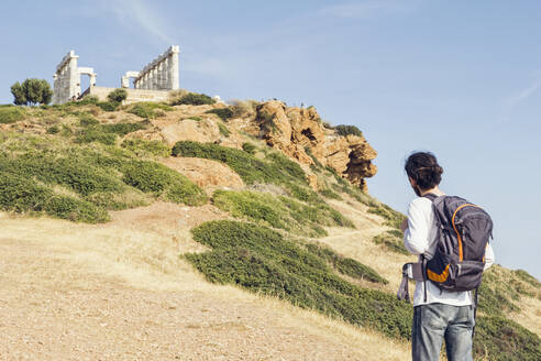 Tourost mit Blick auf die antike Ruine des Poseidon-Tempels, Kap Sounion, Attika, Griechenland - MAMF01003