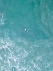 Luftaufnahme eines einsamen Surfers, der über blauem Wasser in der Nähe von Kapstadt, Südafrika, treibt. - AAEF06307