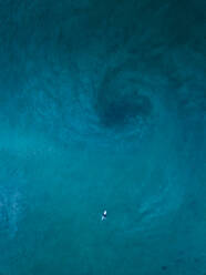 Luftaufnahme eines einsamen Surfers, der über blauem Wasser in der Nähe von Kapstadt, Südafrika, treibt. - AAEF06308