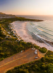 Luftaufnahme von geparkten Autos in der Nähe von Scarborough Beach bei Sonnenuntergang, Südafrika. - AAEF06344