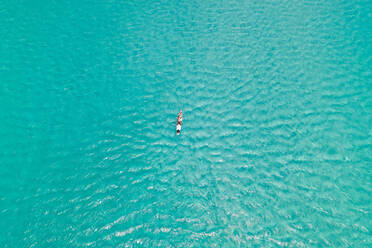 Aerial view of woman practicing standup paddle over transparent water, South Africa. - AAEF06346