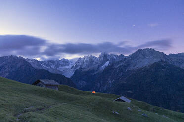 Stars over tent and huts overlooking Piz Badile and Piz Cengalo, Tombal, Soglio, Valbregaglia, Canton of Graubunden, Switzerland, Europe - RHPLF13451