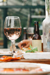 Close-up of wineglass by food on dining table at yard - MASF16150