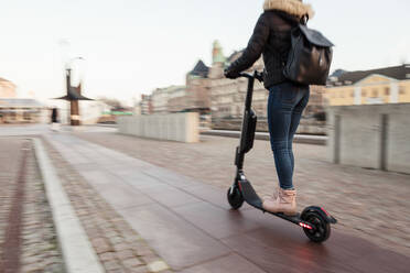 Unscharfe Bewegung von Teenager-Mädchen fahren elektrische Push-Roller auf der Straße in der Stadt - MASF16164