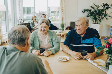 Ältere ältere Freunde unterhalten sich am Esstisch in einem Pflegeheim - MASF16247