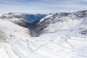 Blick aus der Drohne auf eine verschneite Bergstraße, Giogo di Santa Maria (Umbrail-Pass), Stilfserjoch, Provinz Sondrio, Valtellina, Lombardei, Italien, Europa - RHPLF13594