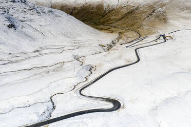 Luftaufnahme einer Drohne von der S-förmigen Straße zum Stilfserjoch in der verschneiten Landschaft, Bormio, Provinz Sondrio, Valtellina, Lombardei, Italien, Europa - RHPLF13599