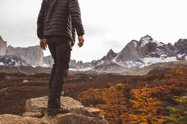 Cropped hiker standing on stone in mountains - CAVF72722