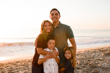 Family of Four Smiling at Camera, Embracing at Sunset - CAVF72753