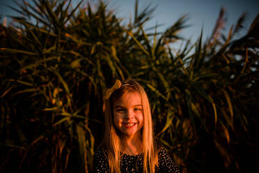 Young Girl Smiling at Camera During Sunset - CAVF72756