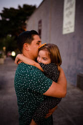 Vater und Tochter umarmen sich auf der Straße - CAVF72762